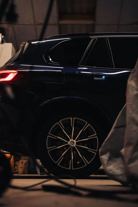 Zwarte BMW X5 in werkplaats met strakke reflecties na keramische coating — DOB Detailing
