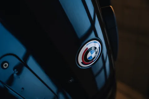 BMW-logo op zwarte motorkap met diepe reflectie na lakcorrectie — DOB Detailing Twente